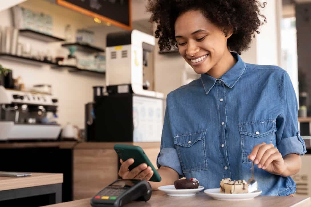 Woman smiling whilst operating a POS device